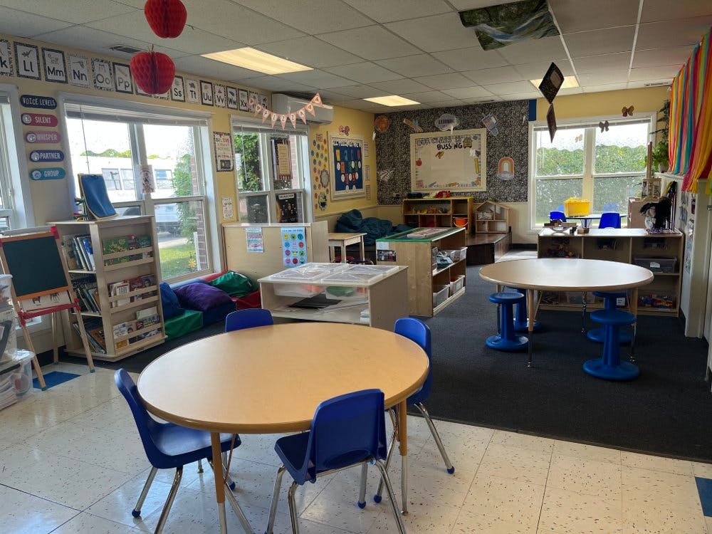An empty classroom with small tables and chairs