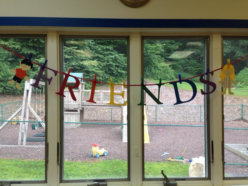 Friends banner hanging in a window overlooking a playground