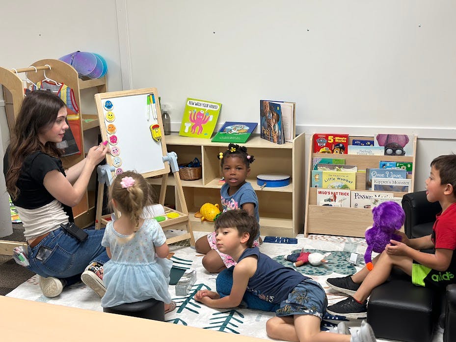 Adult and children interacting in a classroom setting