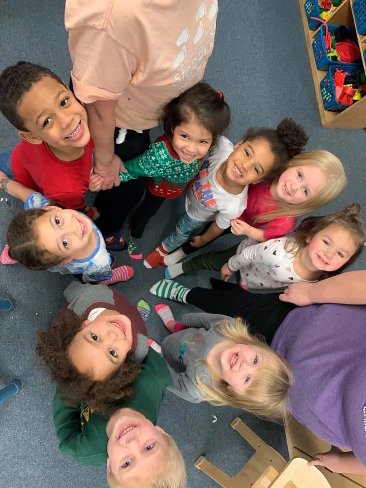 Group of children and adults looking up at the camera