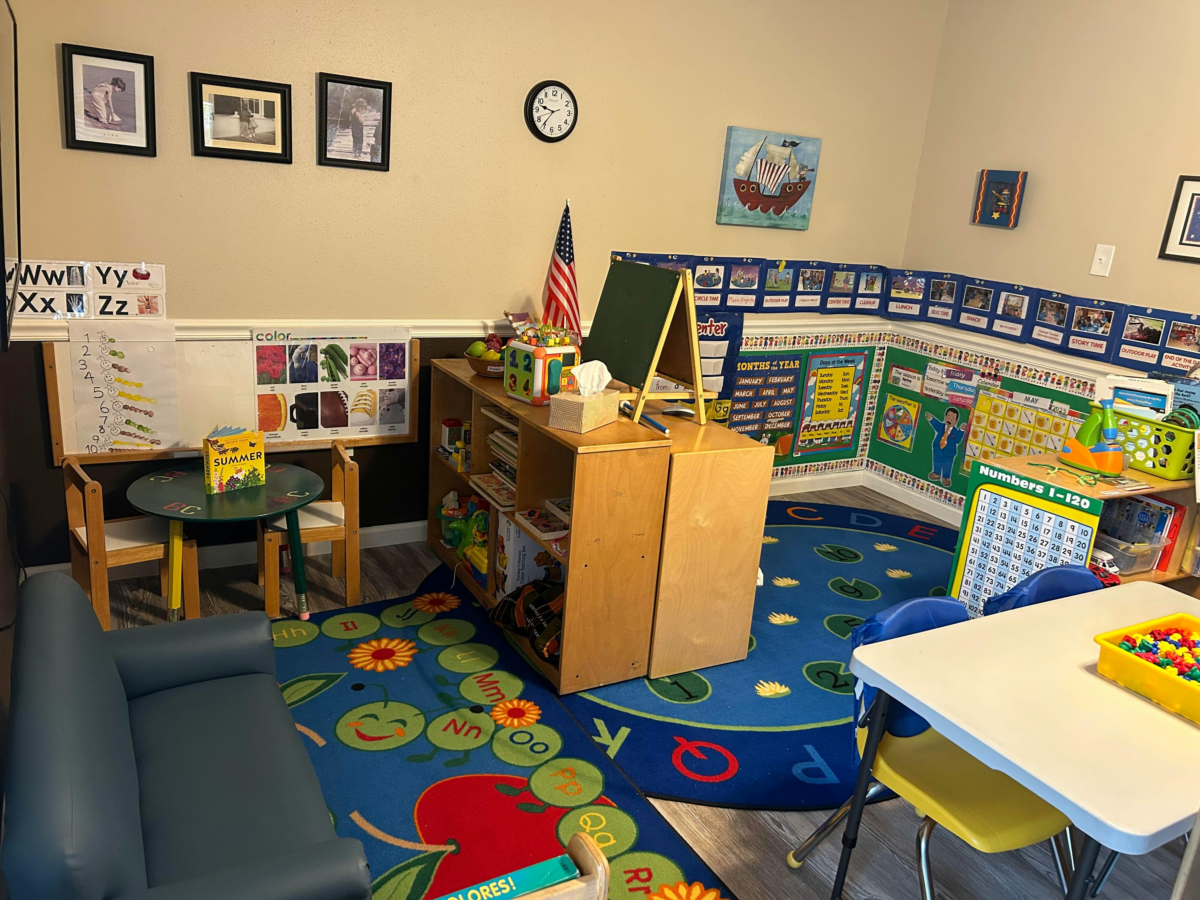 Classroom with small tables, chairs, and educational posters