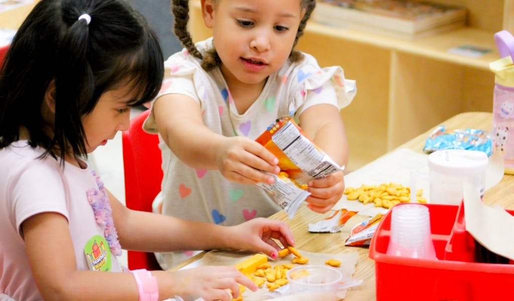 Two children at a table with snacks