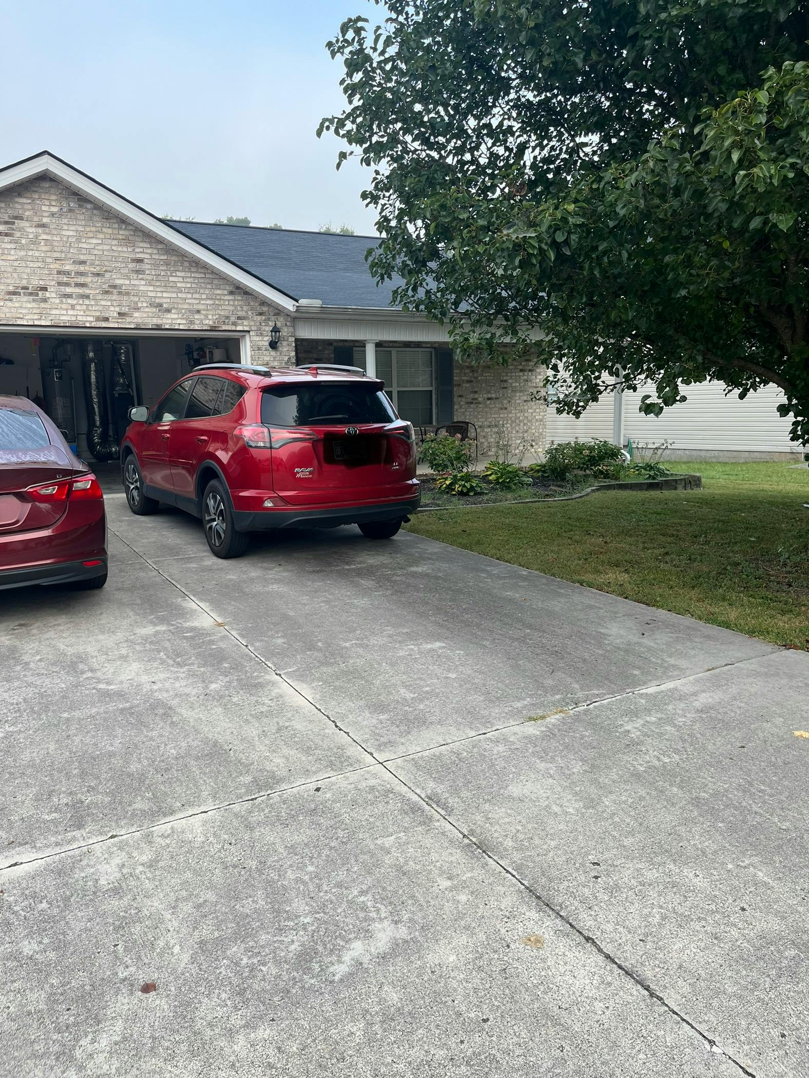 Red SUV parked in a driveway in front of a house