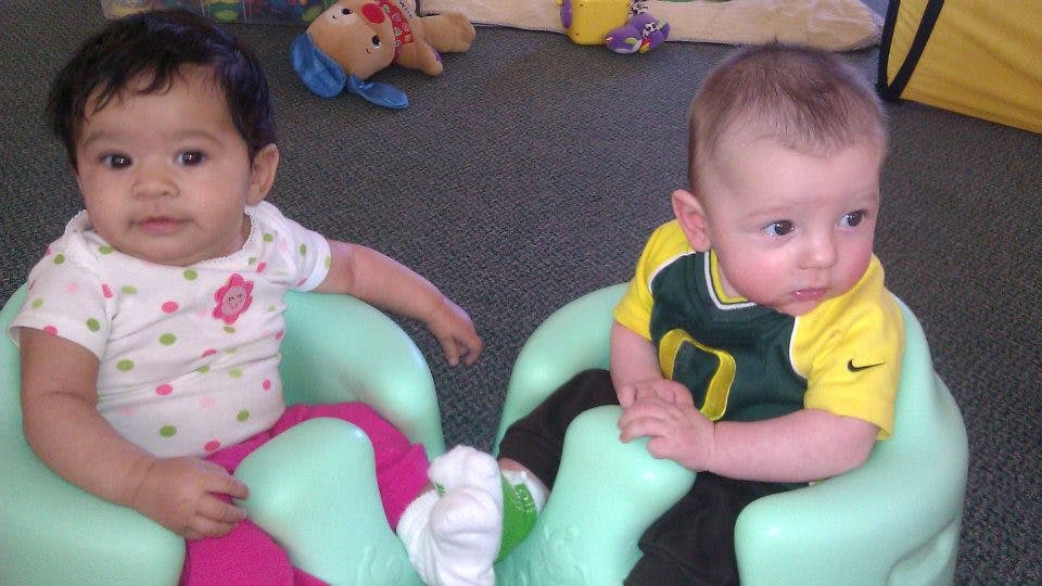Two babies sitting in chairs
