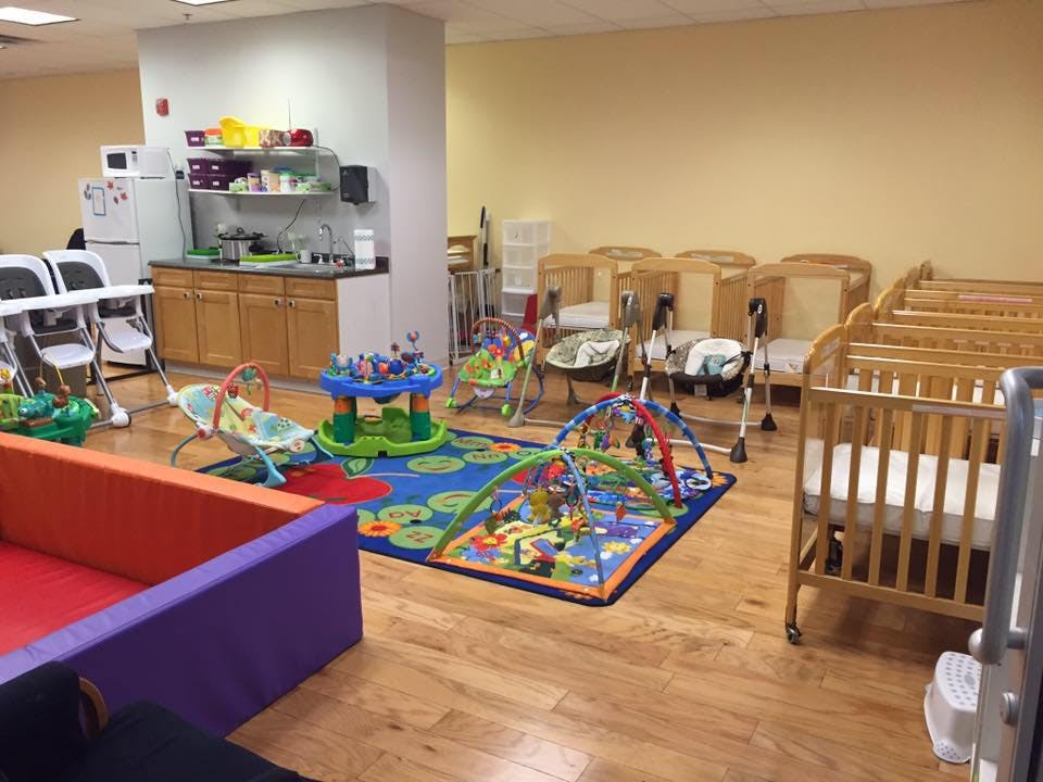 Daycare room with cribs, playmats, and high chairs