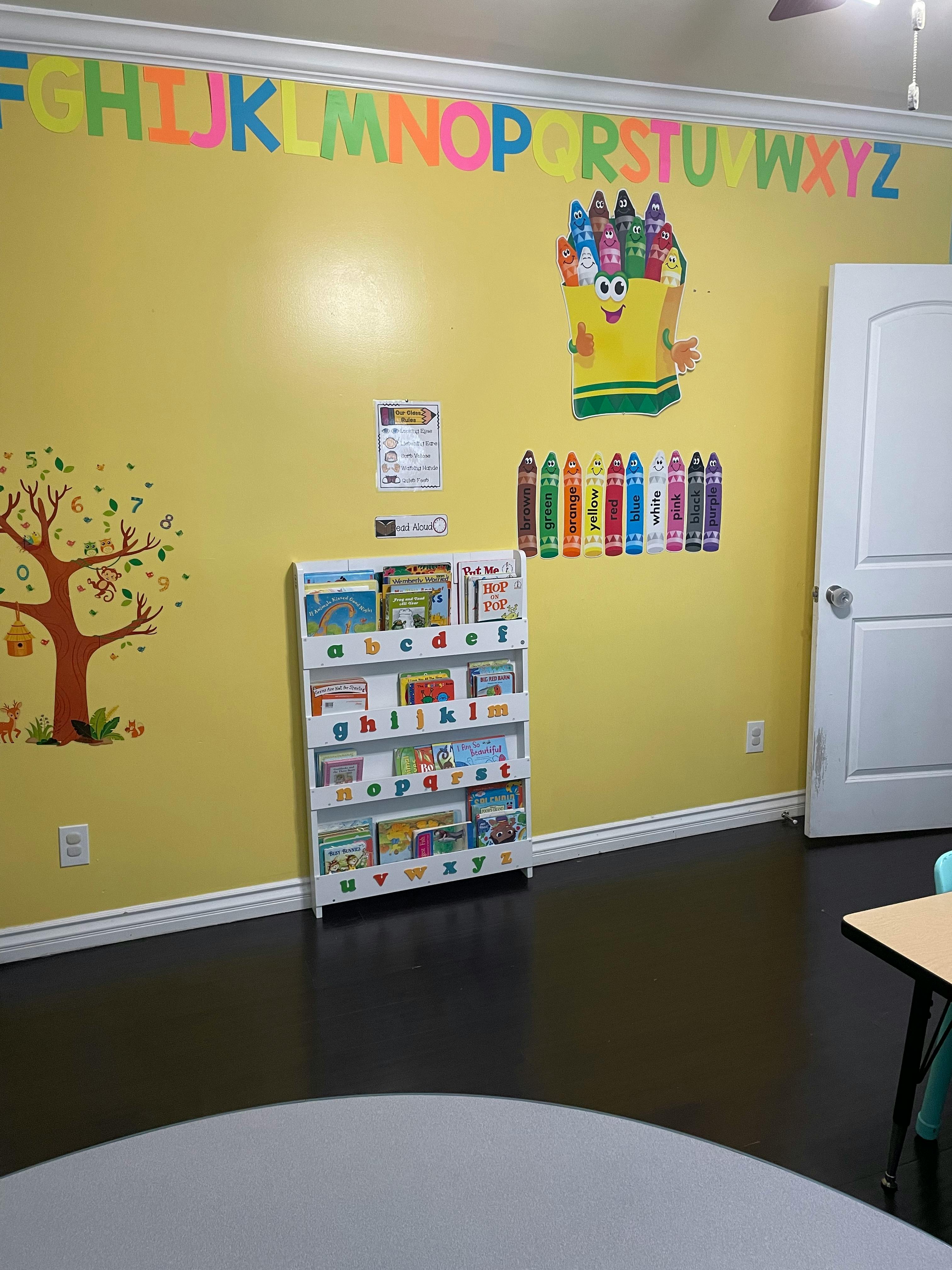 Children's classroom with a bookshelf, alphabet letters, and crayon decorations