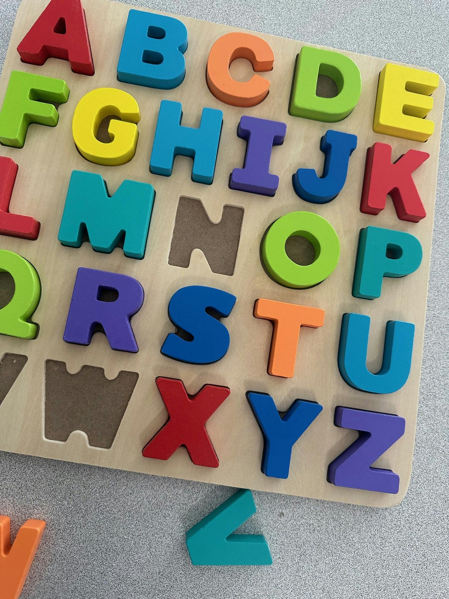 Wooden alphabet letter puzzle with some pieces missing