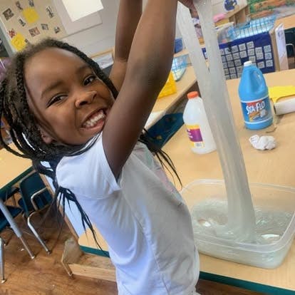 Child playing with slime in a classroom