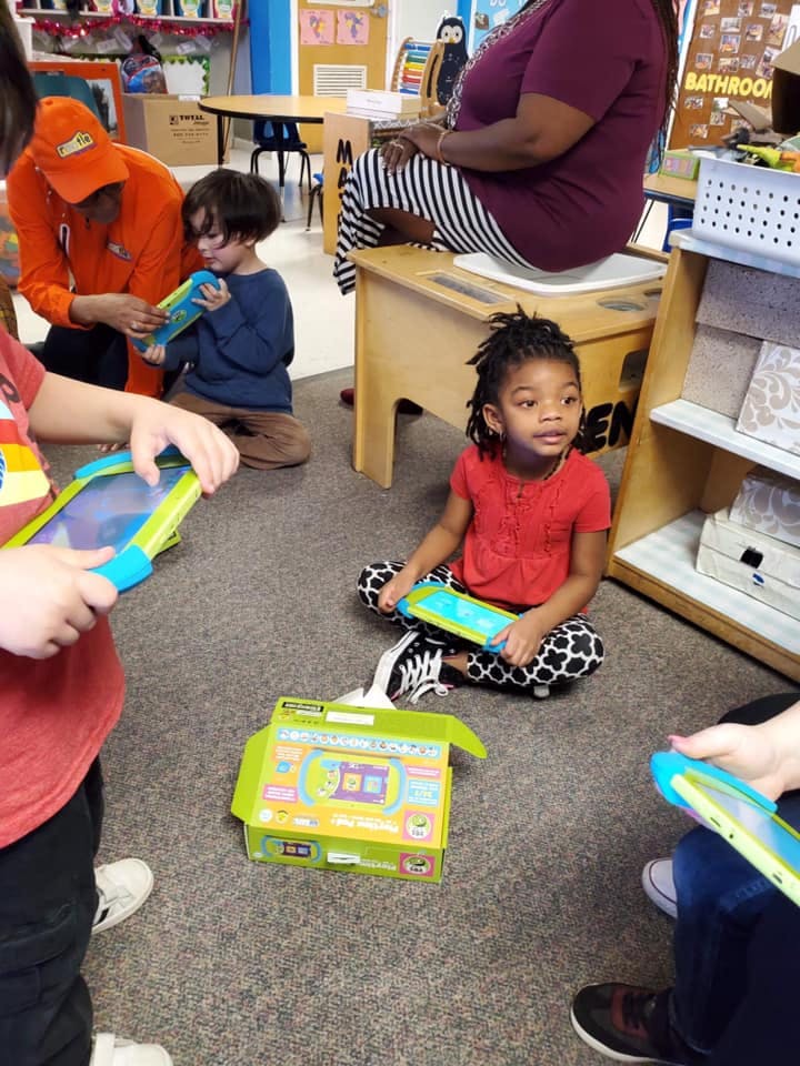 Children and adults playing with learning toys in a classroom