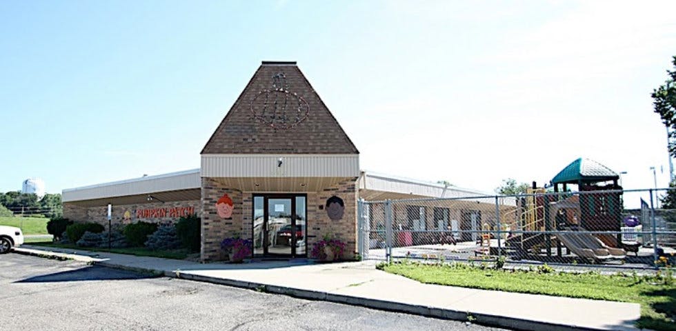 Building with a pointed roof and a playground