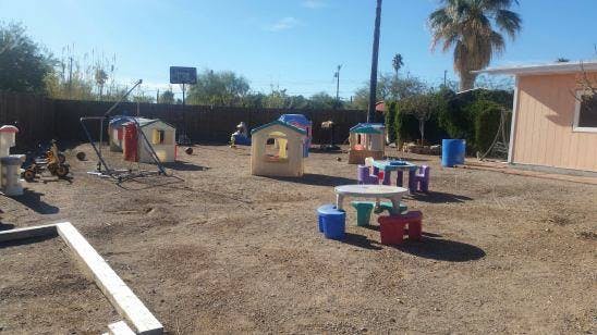 Outdoor play area with small playhouses and tables