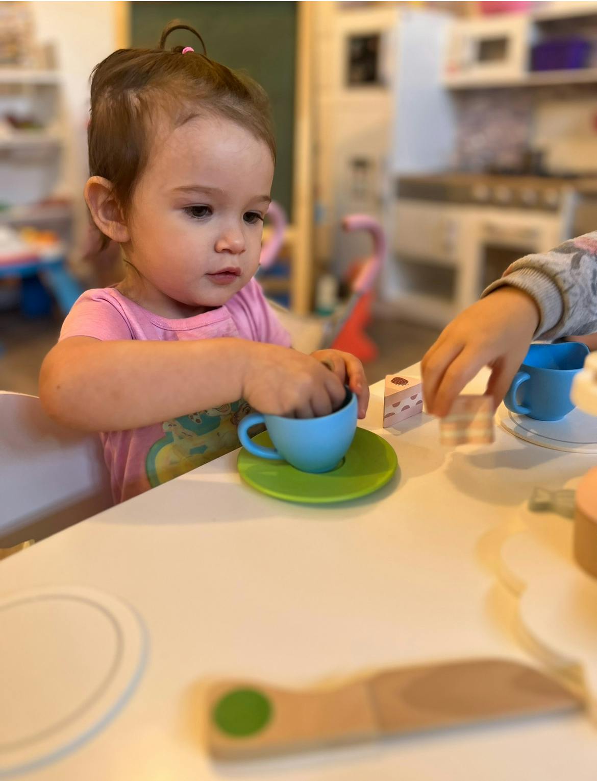 Child playing with a toy teacup and saucer