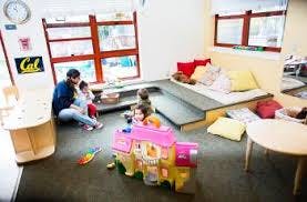 Adult and children playing with toys in a room