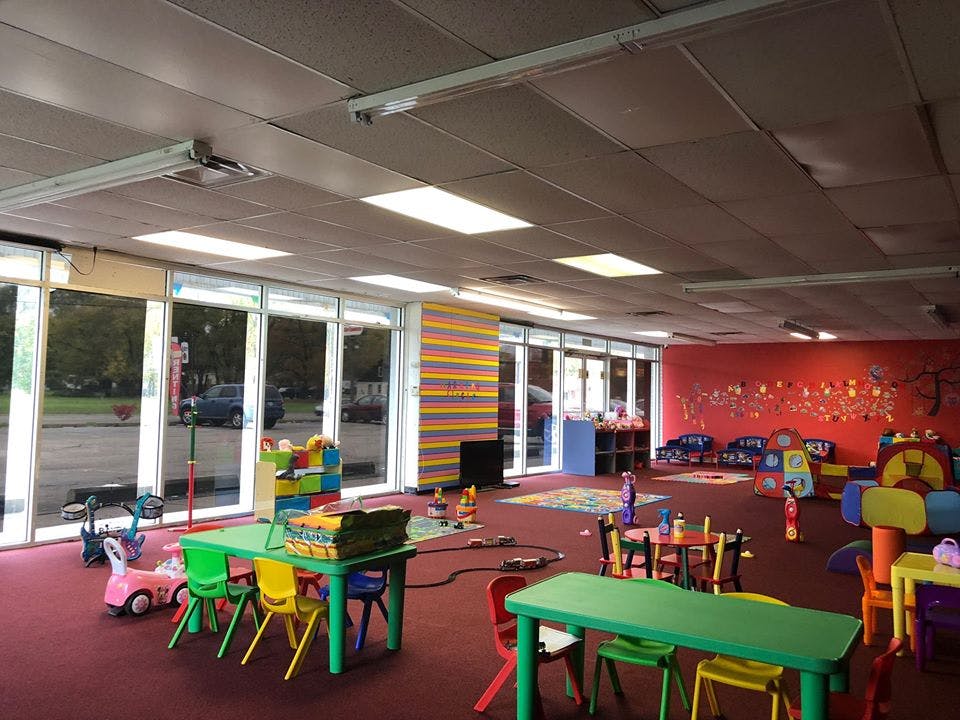 Playroom with small tables and chairs, toys, and large windows