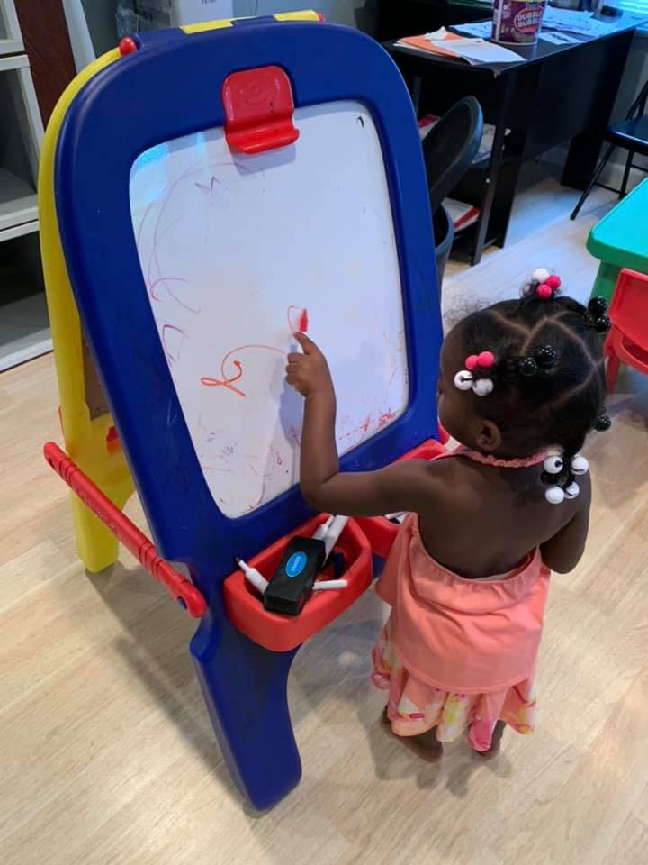 Child drawing on an easel