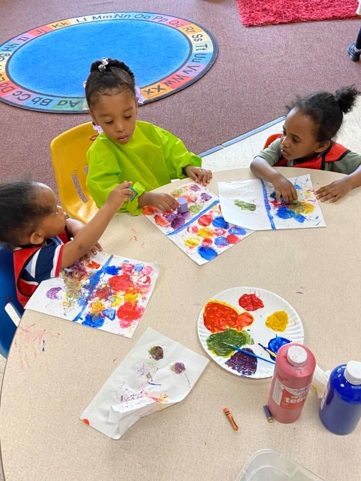Three children painting at a table