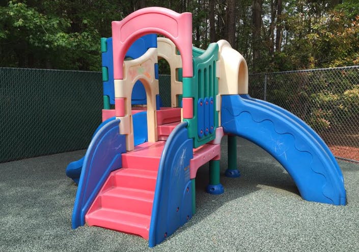 Colorful playground structure with stairs and slides on rubberized ground