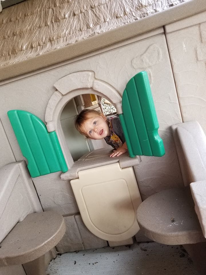 Child looking out of a playhouse window
