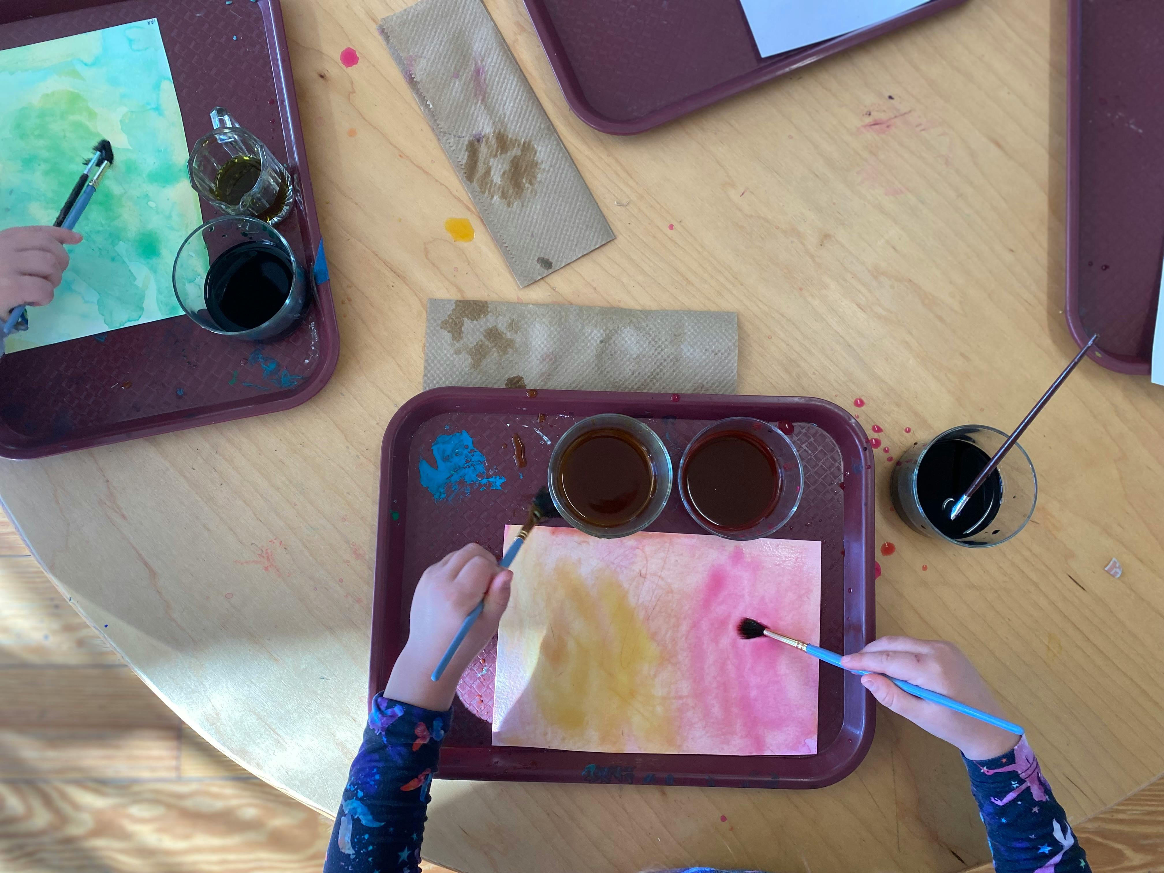 Children painting with watercolors at a table