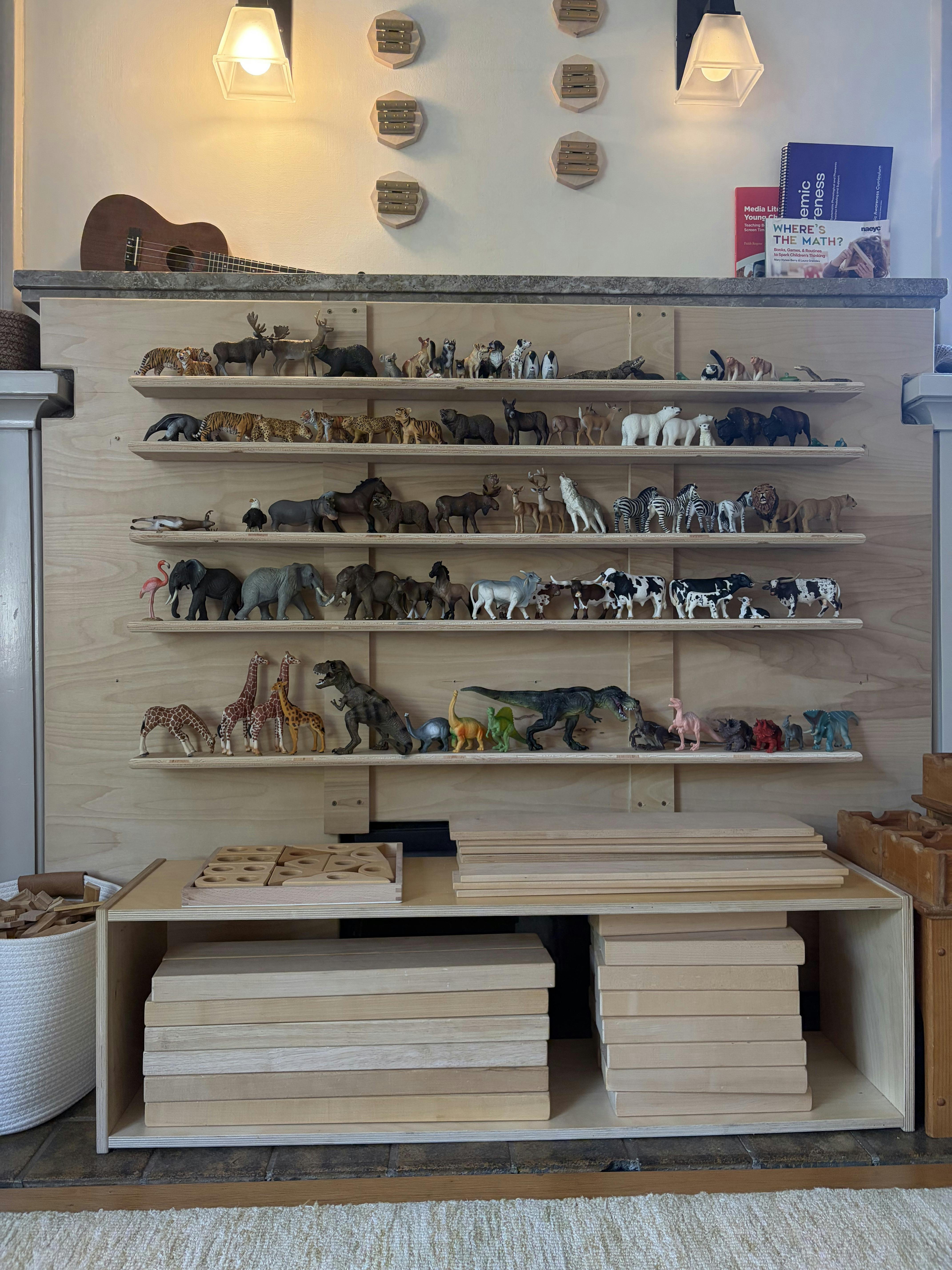 Wooden shelves displaying a large collection of animal and dinosaur figurines