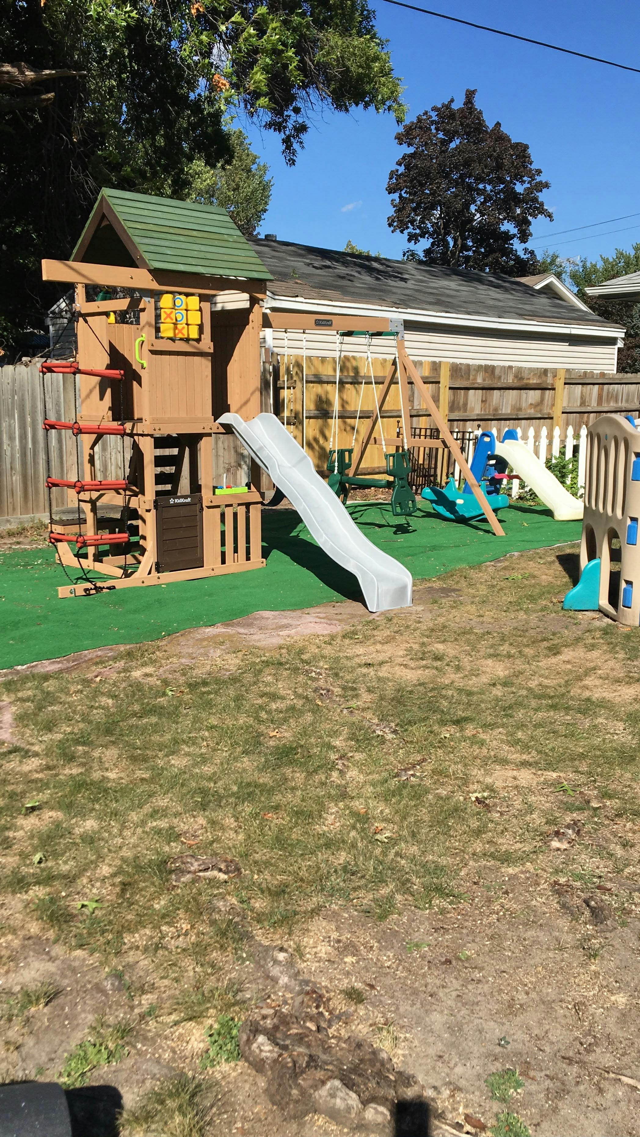 Wooden swing set with slide in a residential backyard