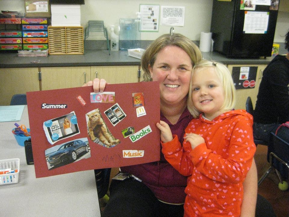 Person and child holding up a collage board with various images and text