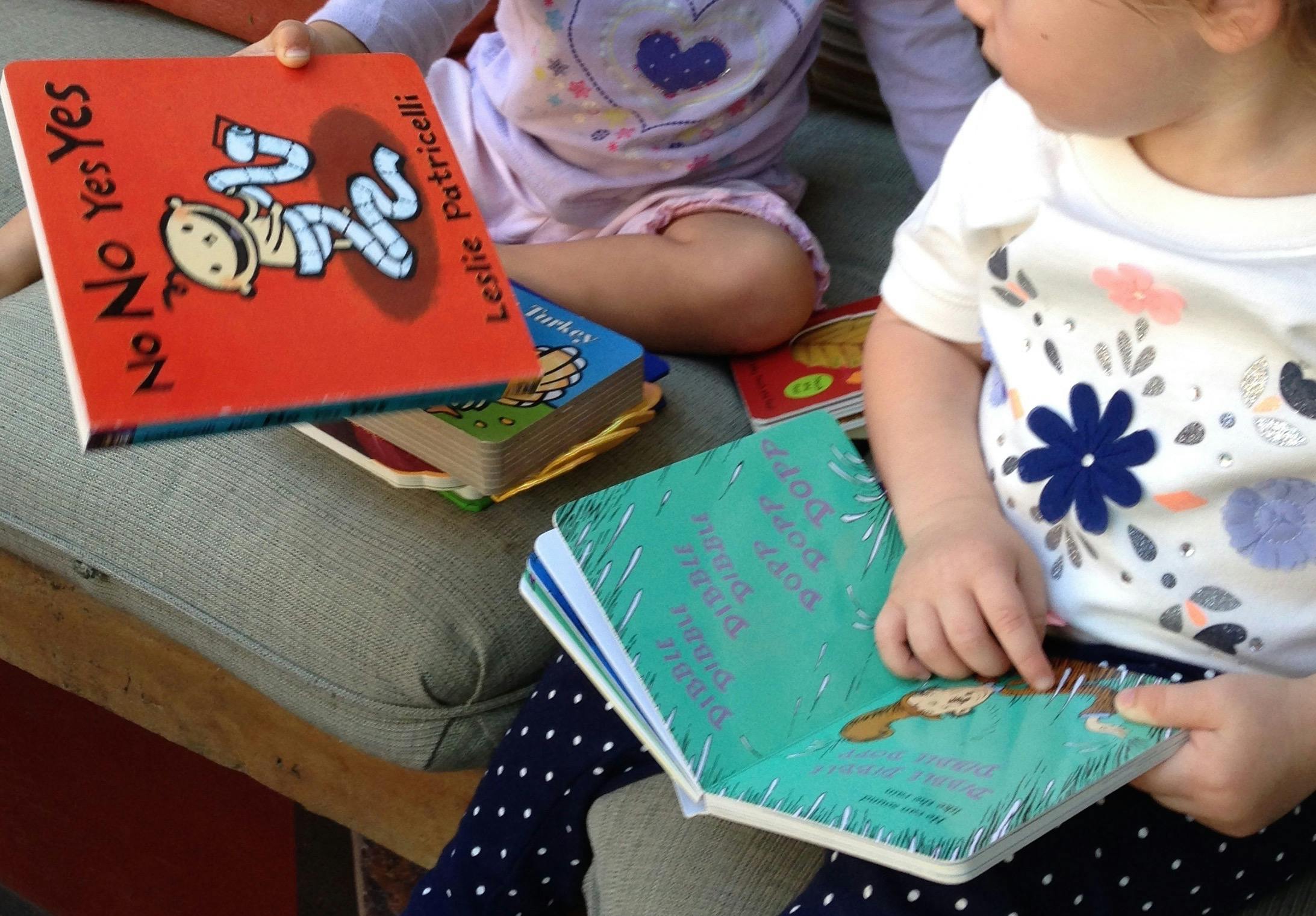 Two children holding and looking at books