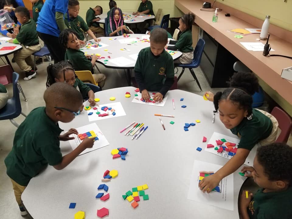Children at tables working with colorful shapes