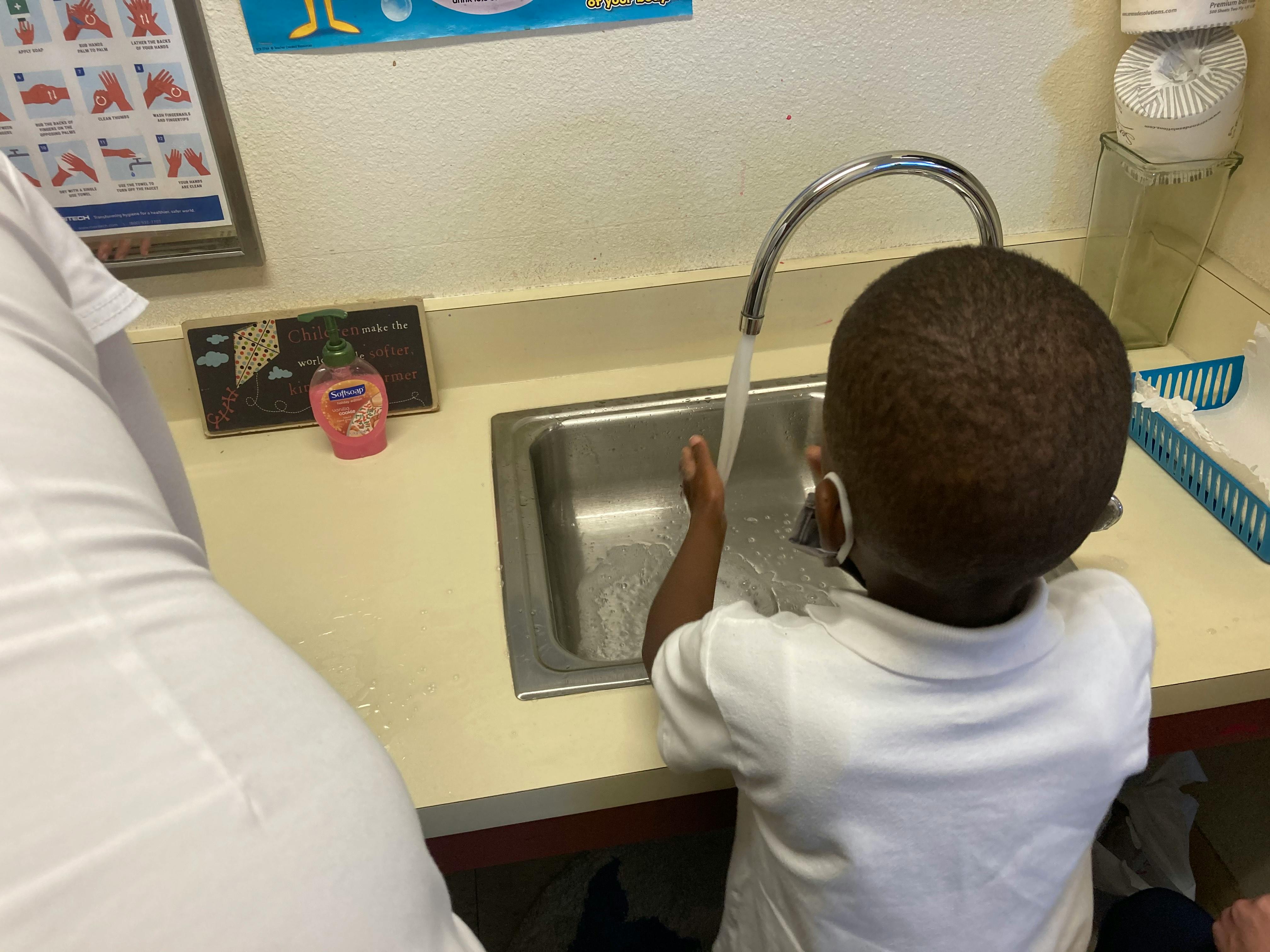 Child washing hands at a sink