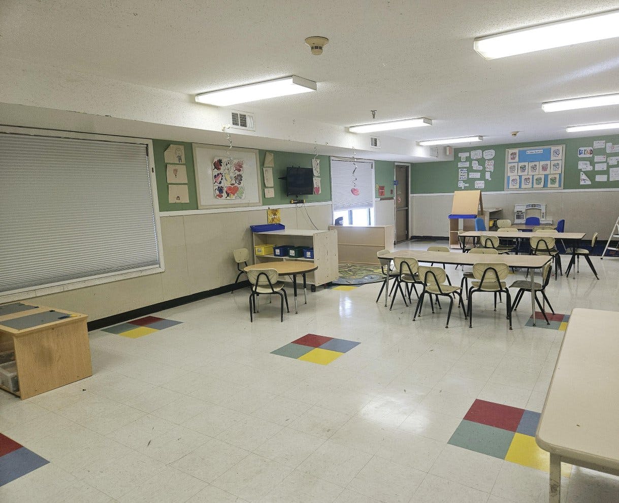 Empty classroom with small tables and chairs