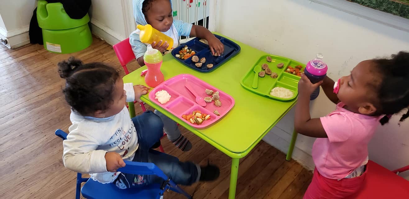 Three children eating at a small table