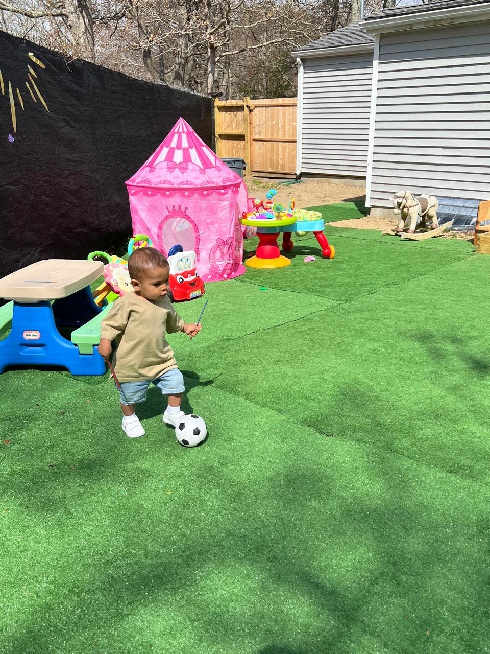 Child playing with a soccer ball on artificial grass