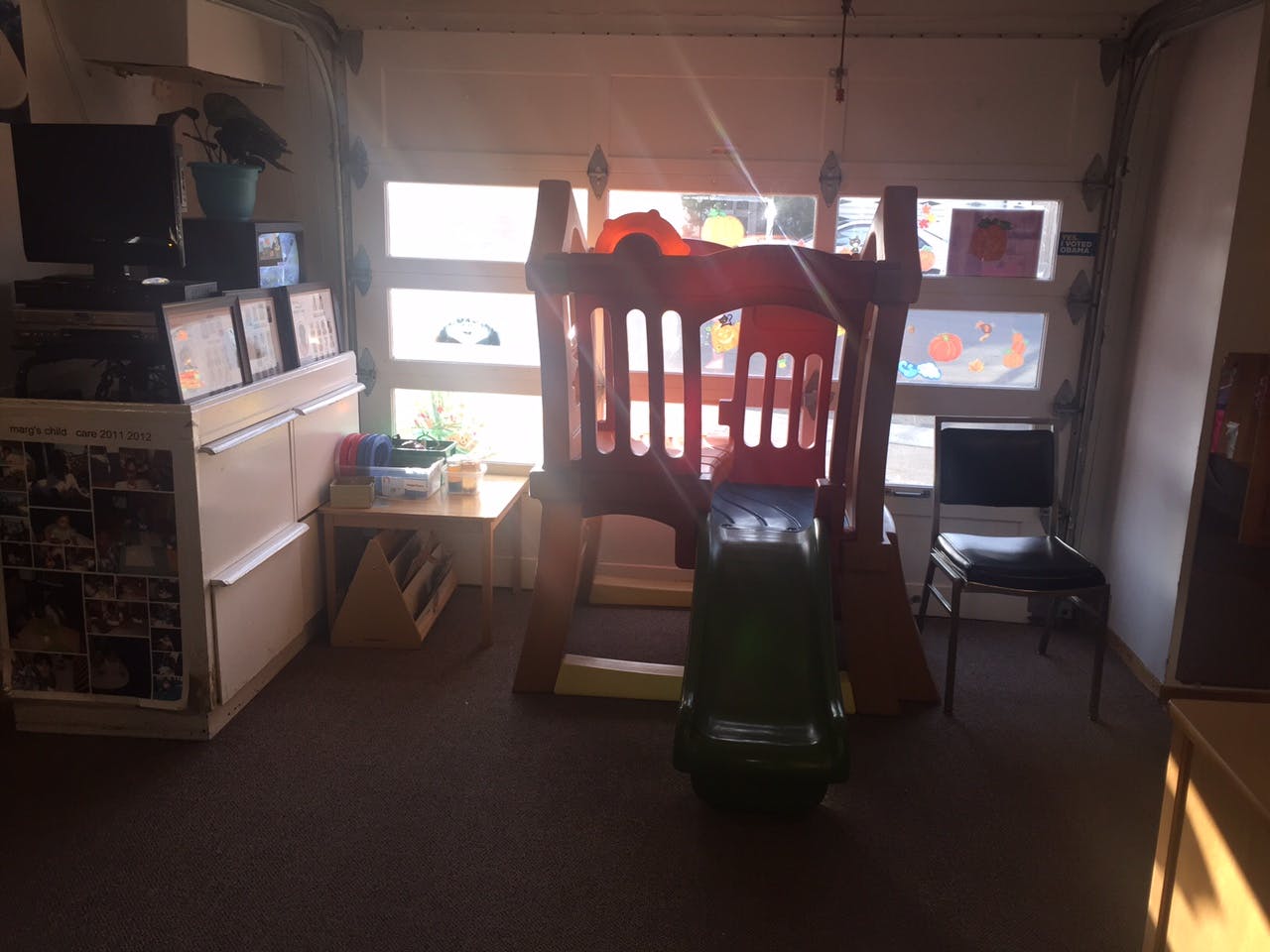 Indoor play structure with a slide in a room with windows