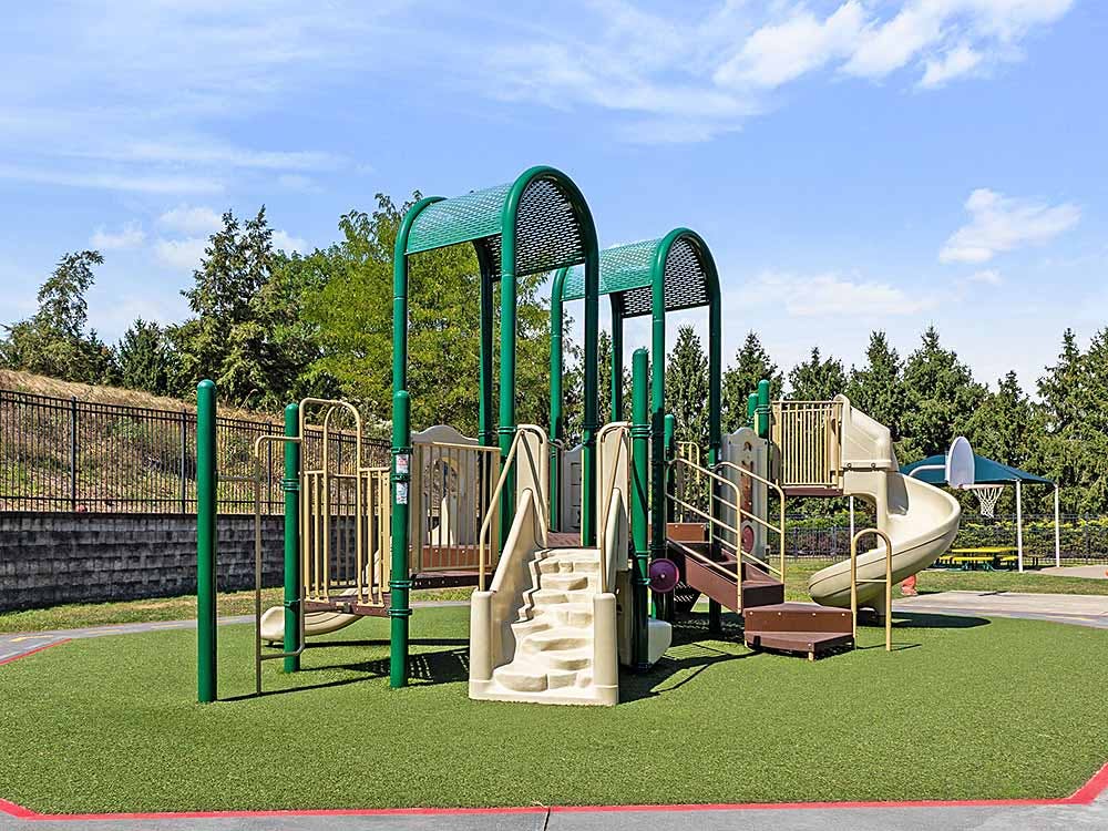 Playground with green turf, slides, and climbing structures