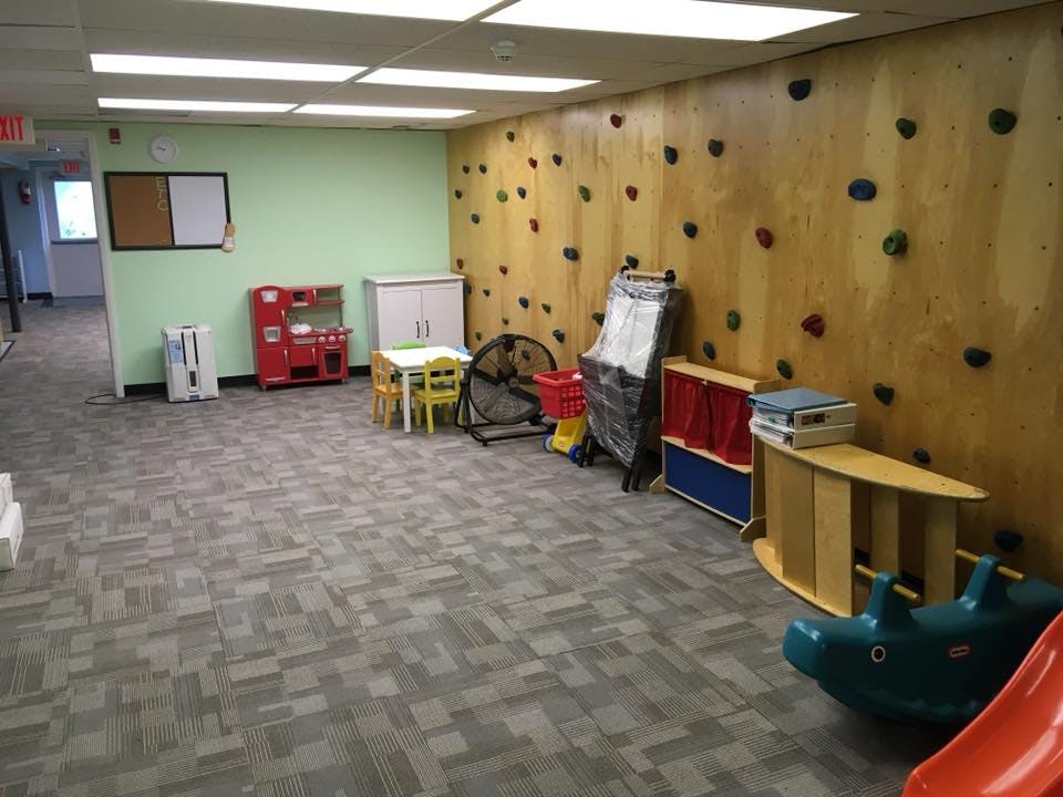 Children's play area with a climbing wall and various toys