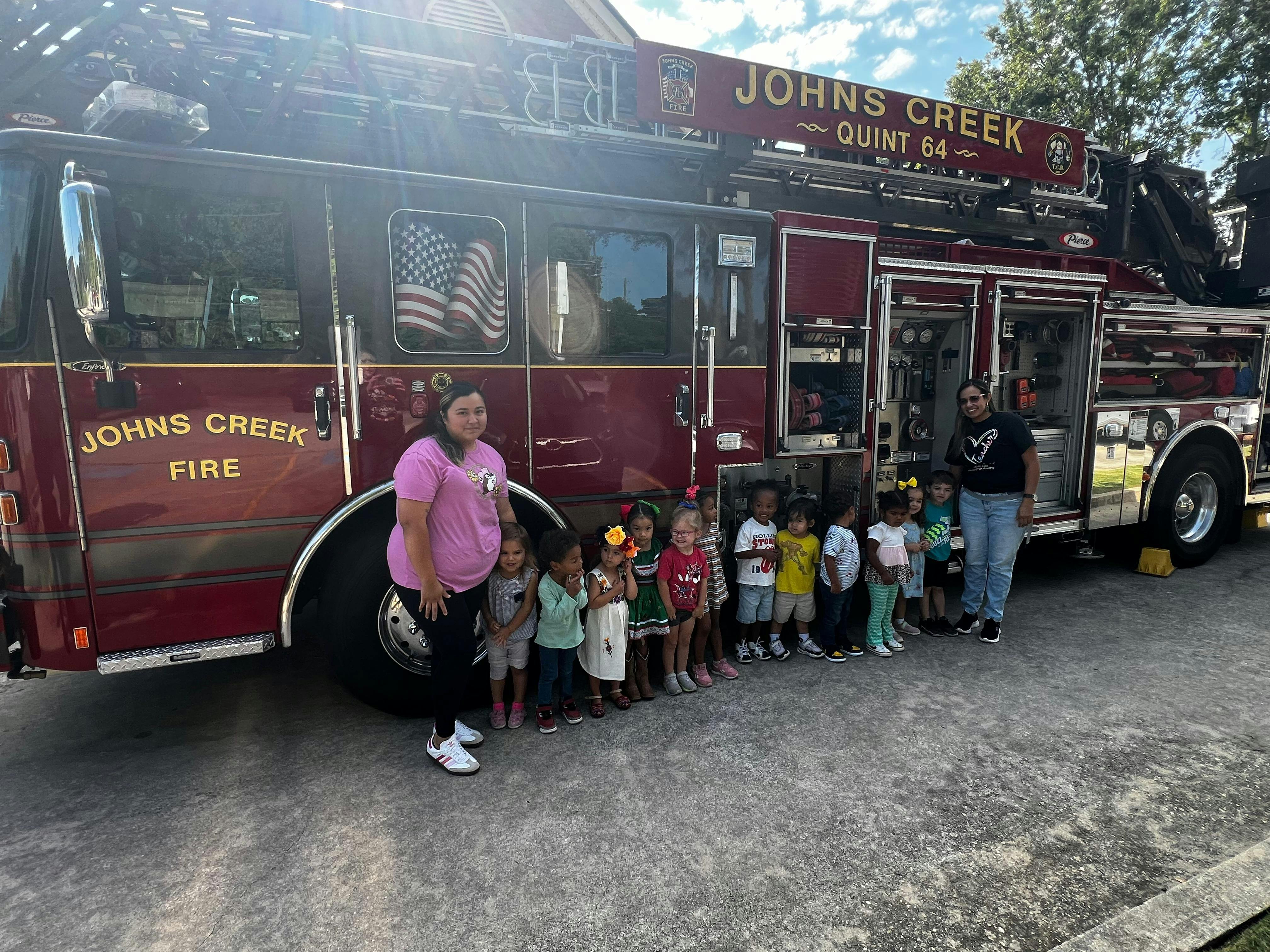 Adults and children standing in front of a fire truck