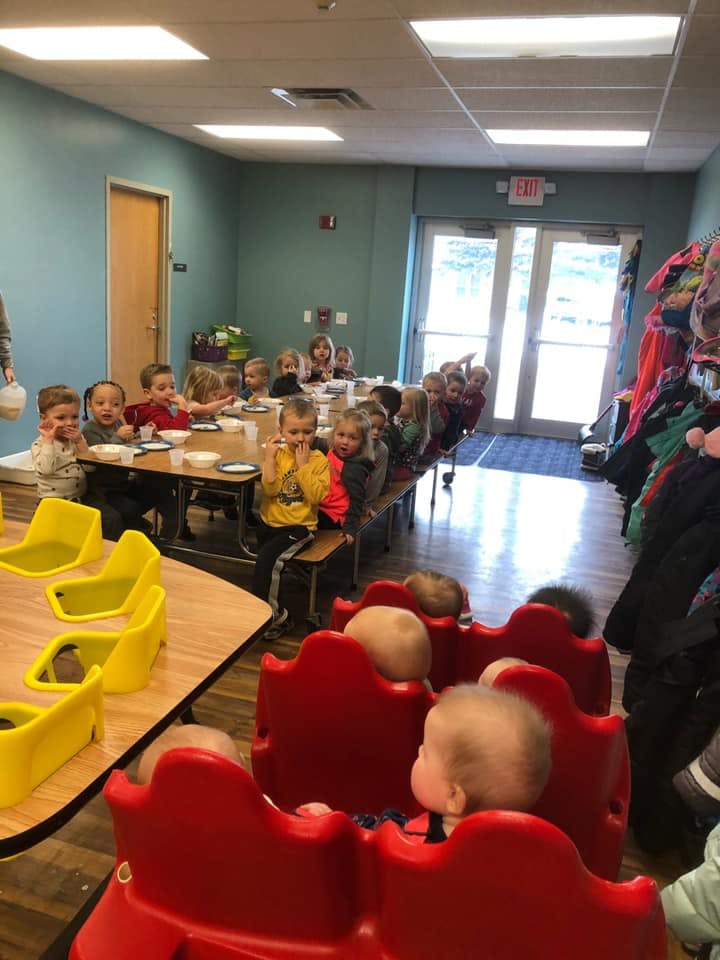 Children sitting at tables in a classroom