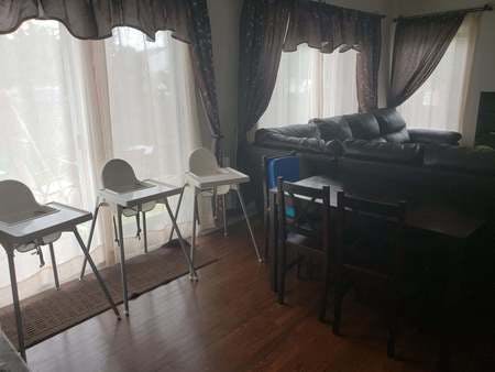 Three high chairs in a room with a sofa and dining table