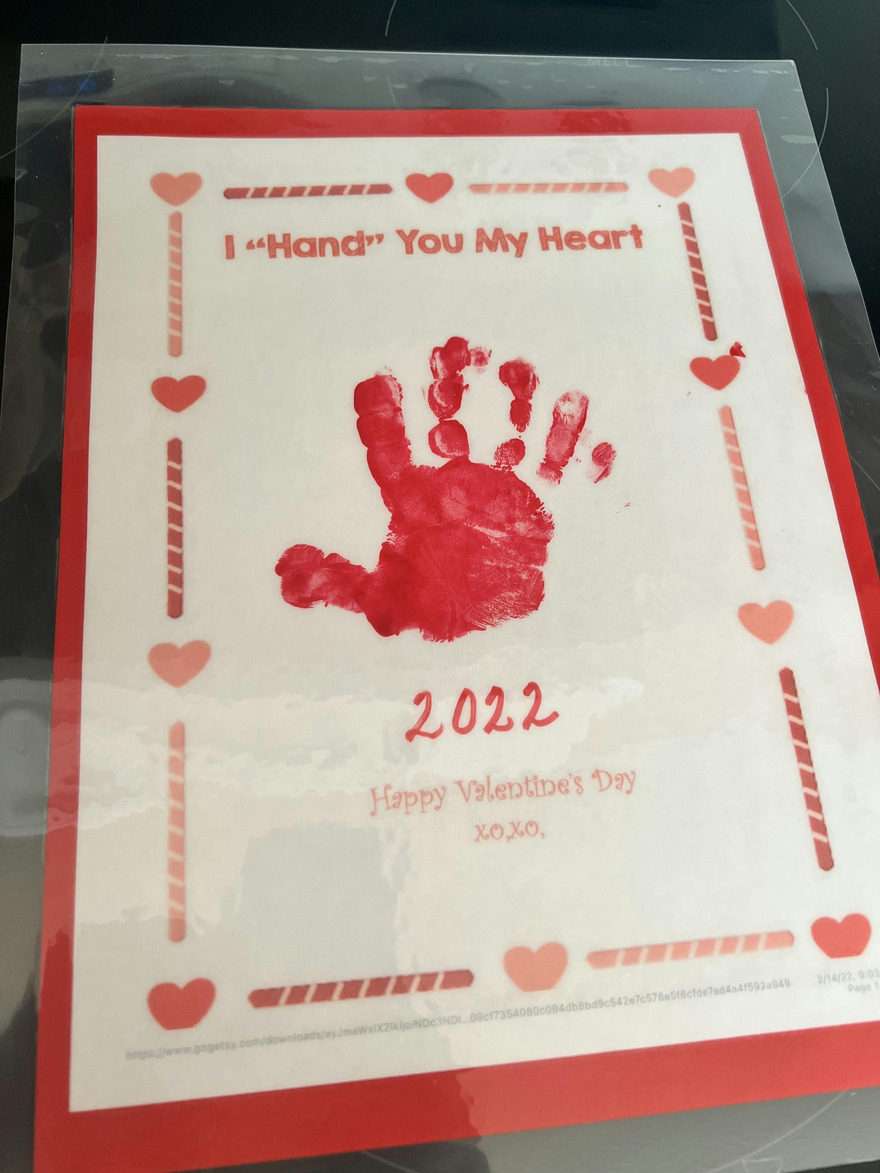 Valentine's Day card with red handprint and text I Hand You My Heart