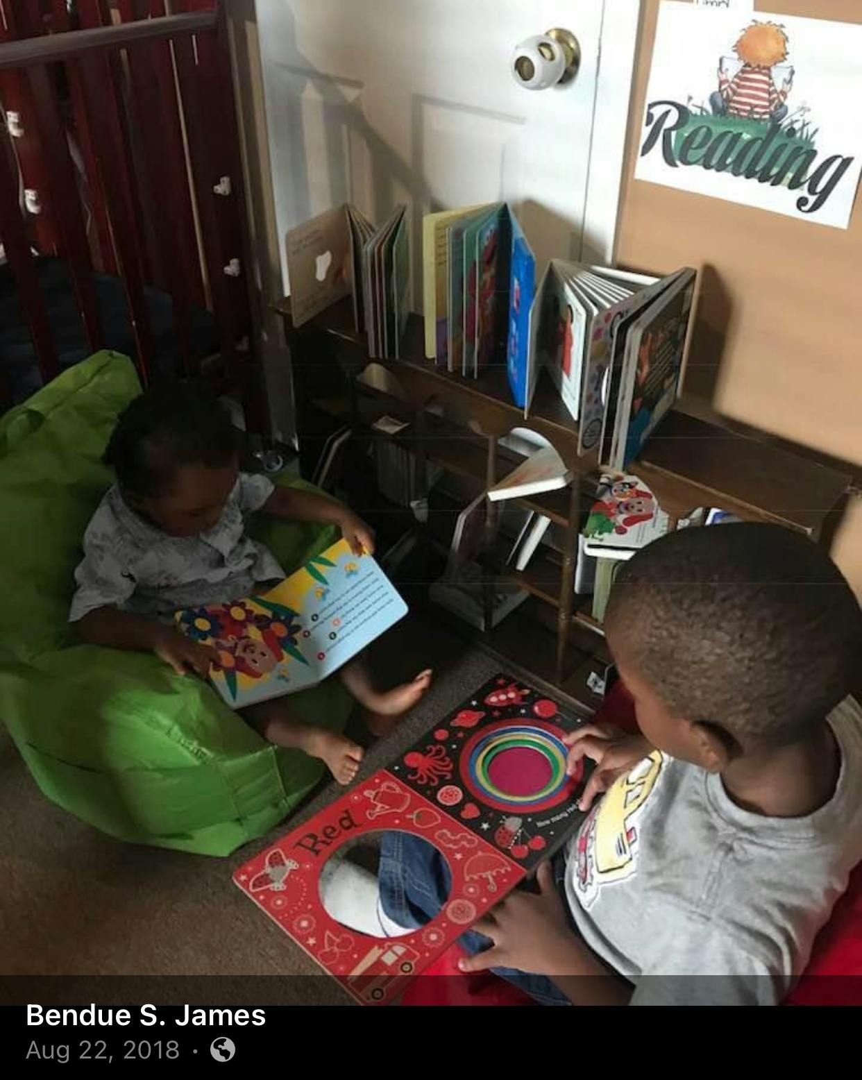 Two children reading books on the floor