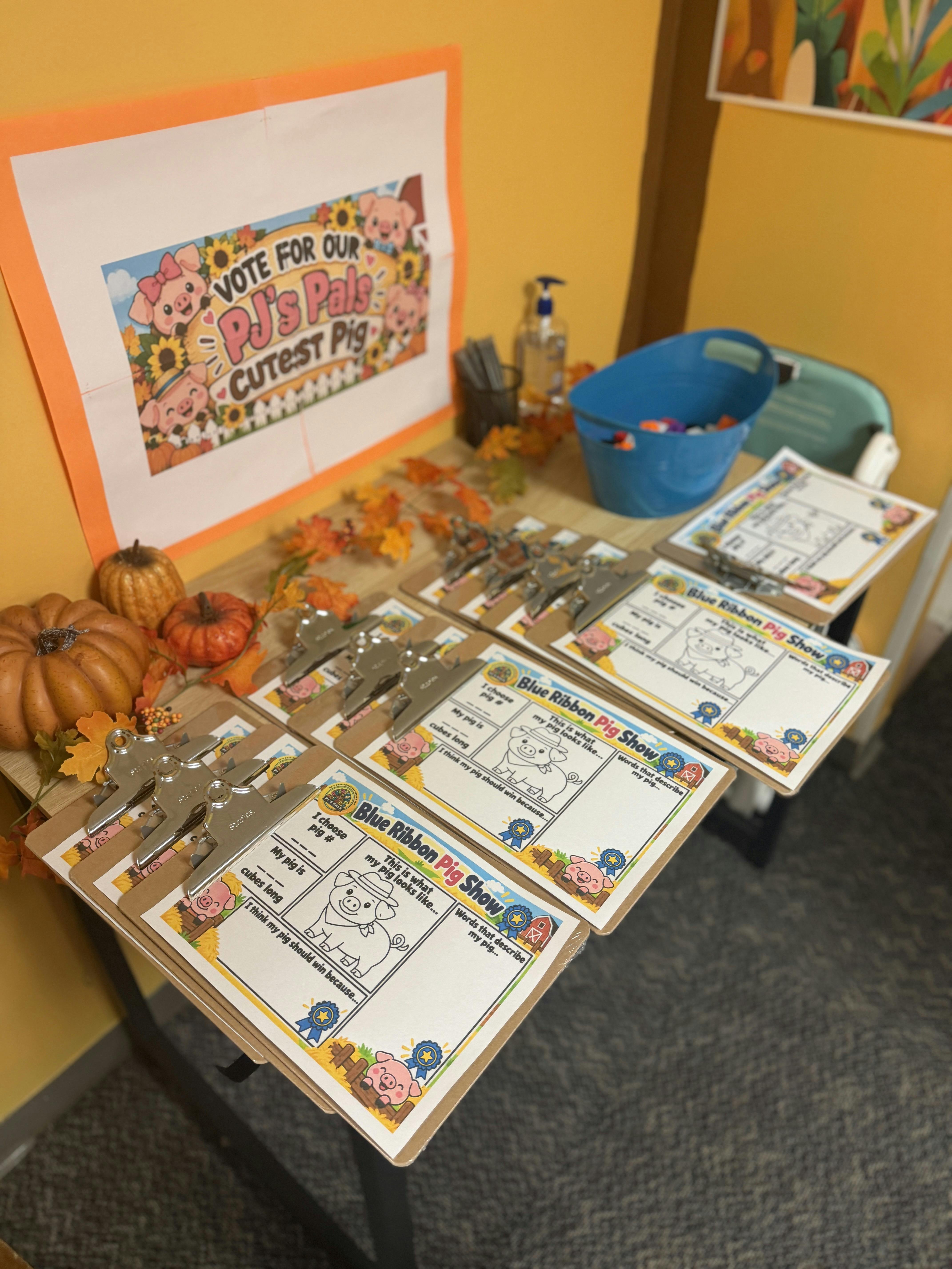 Clipboards with Blue Ribbon Pig Show activity sheets on a table with pumpkins