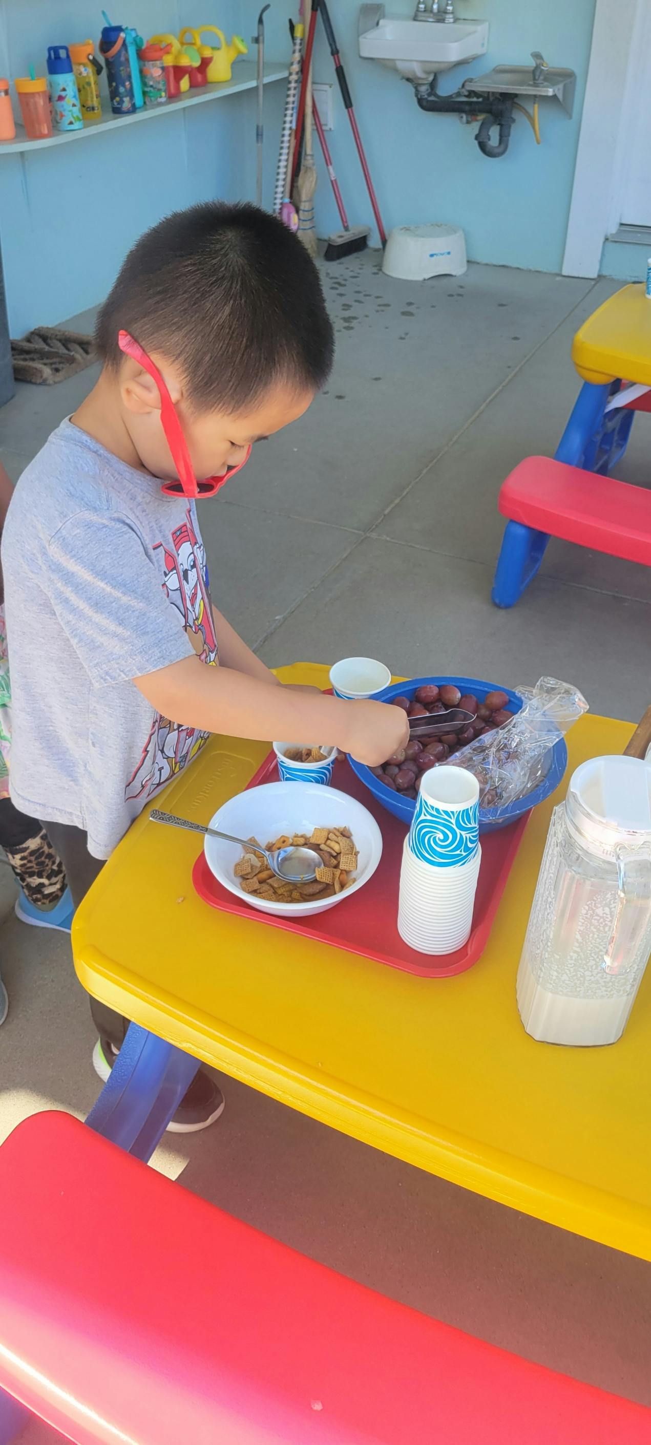 Child serving food from bowls on a yellow table