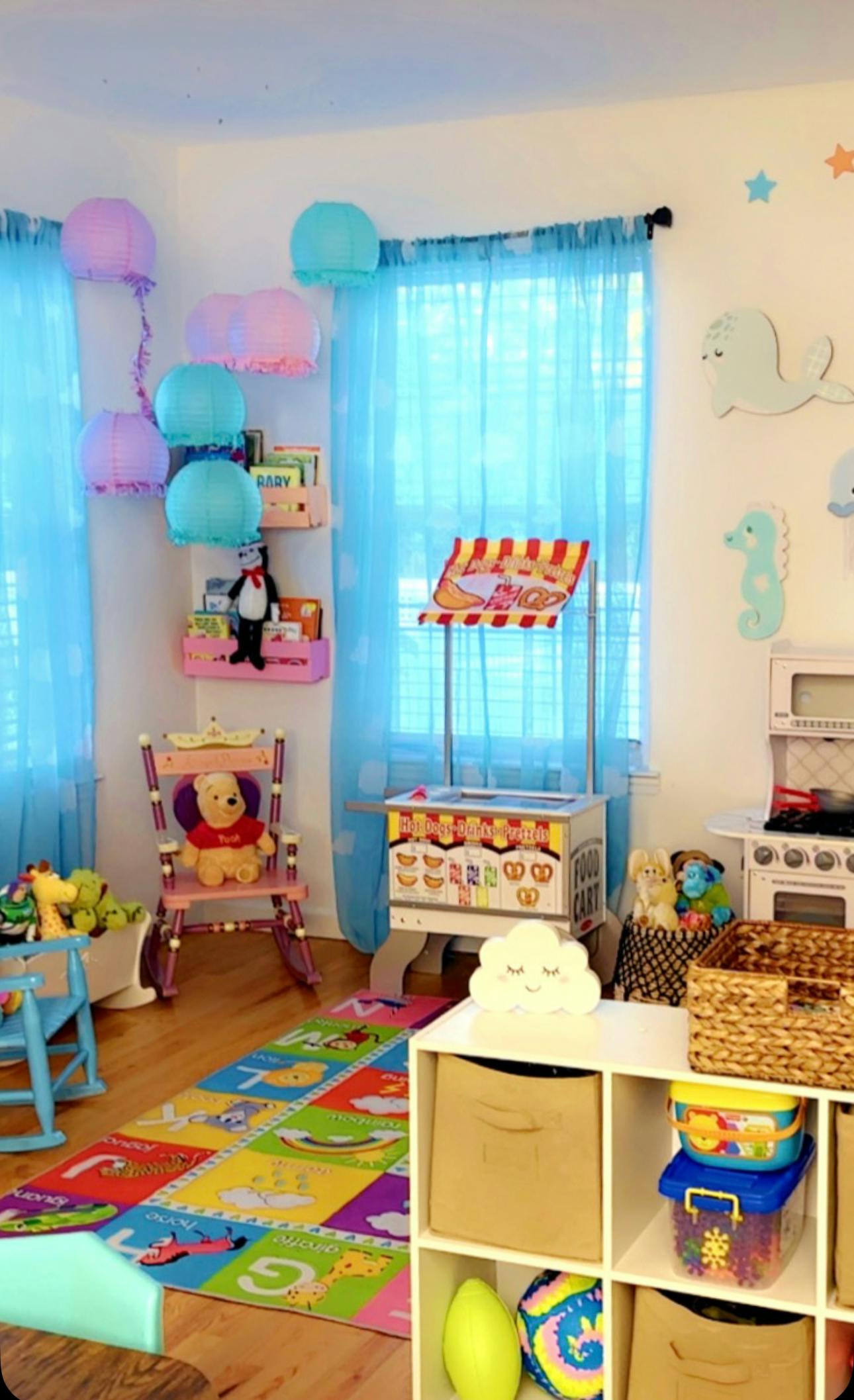 Playroom with colorful rug, toy kitchen, and snack stand