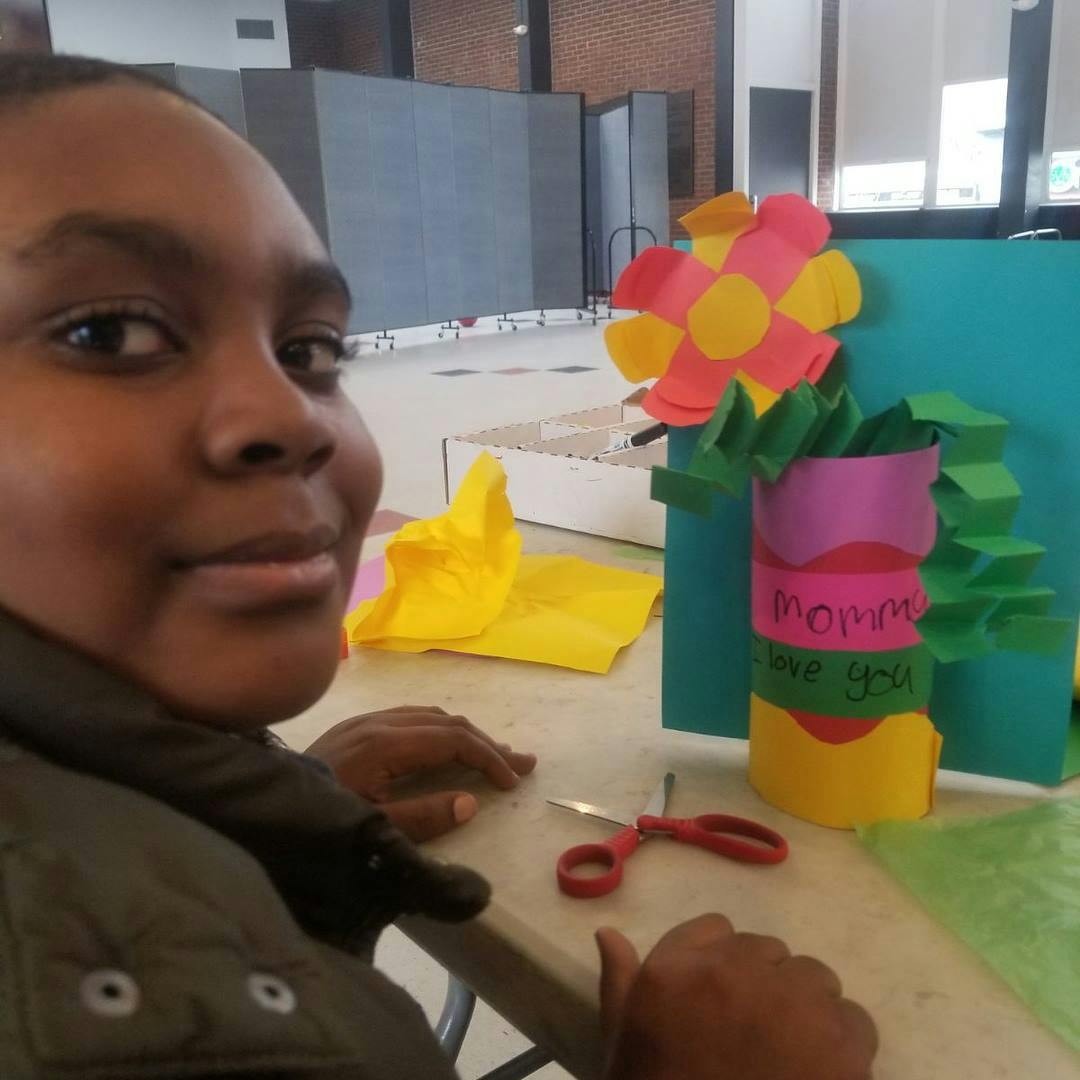 Child making paper crafts with scissors on a table