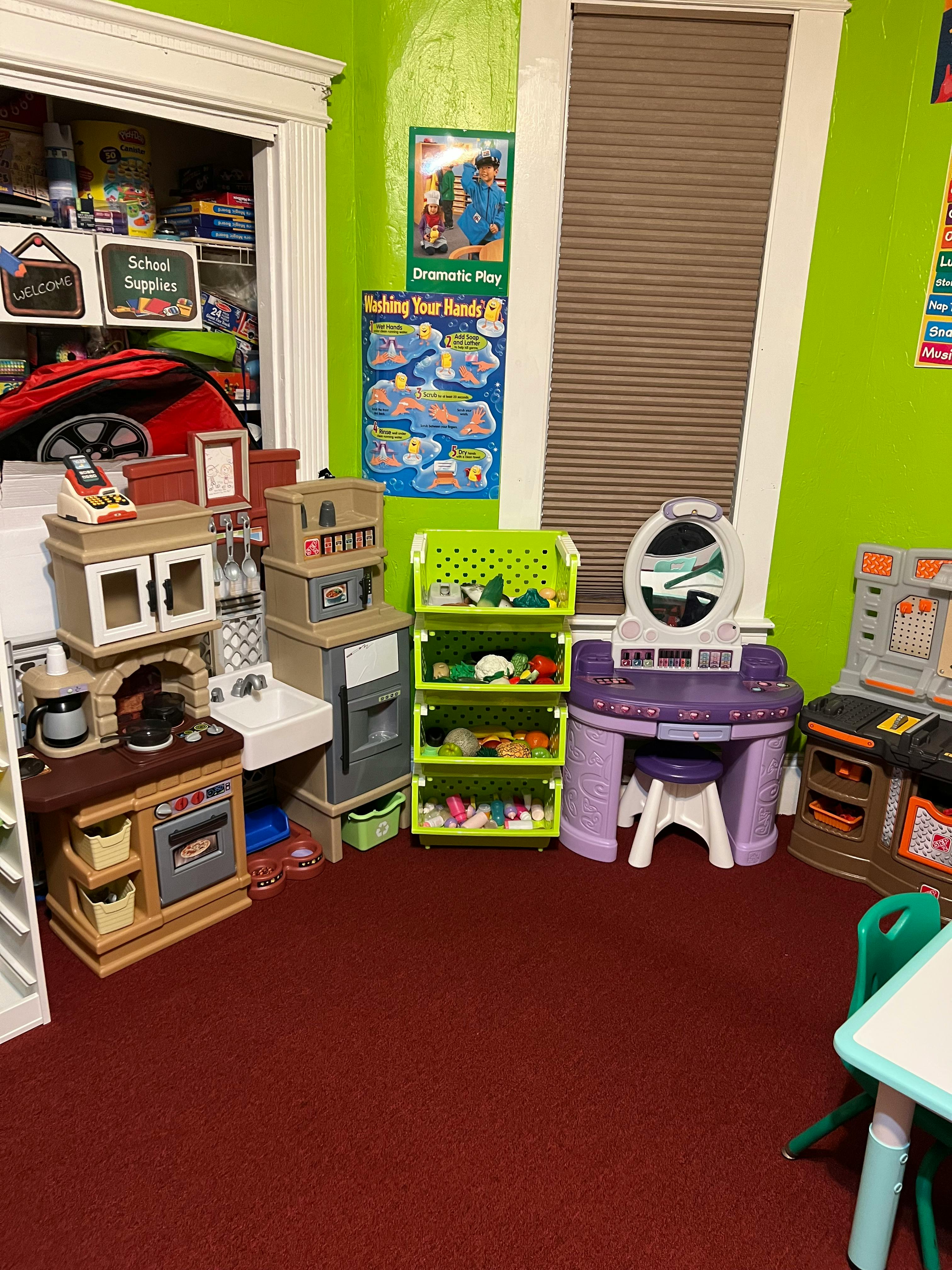 Play kitchen, vanity, and storage shelves in a room with green walls