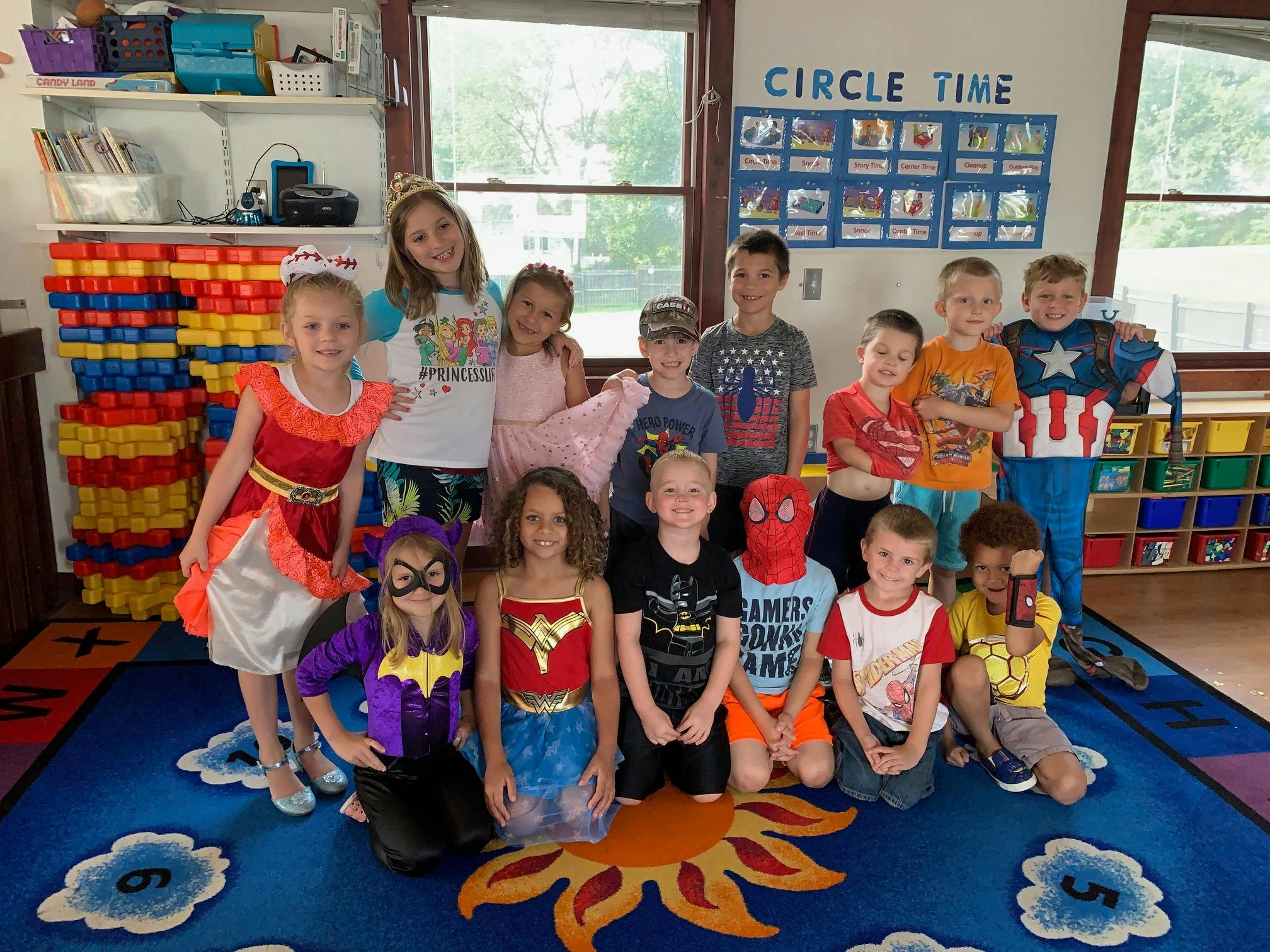 Group of children in costumes posing in a classroom