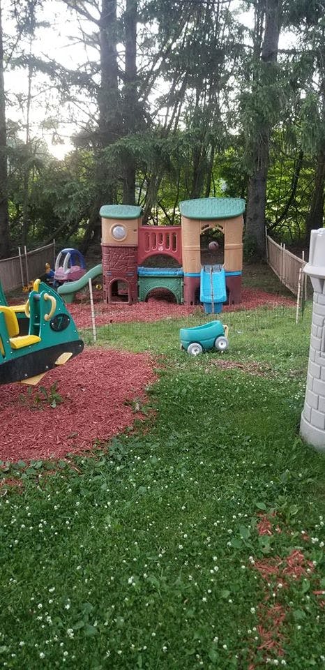 Playground with a plastic play structure, slide, and swing set