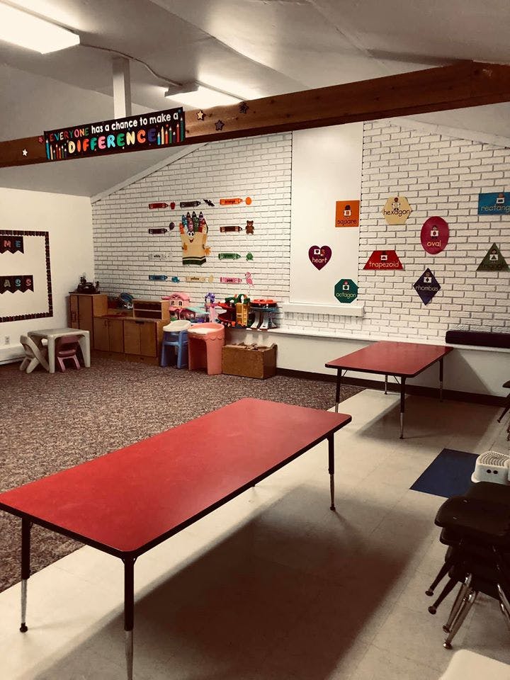 Classroom with red tables and a sign that reads "Everyone has a chance to make a difference"