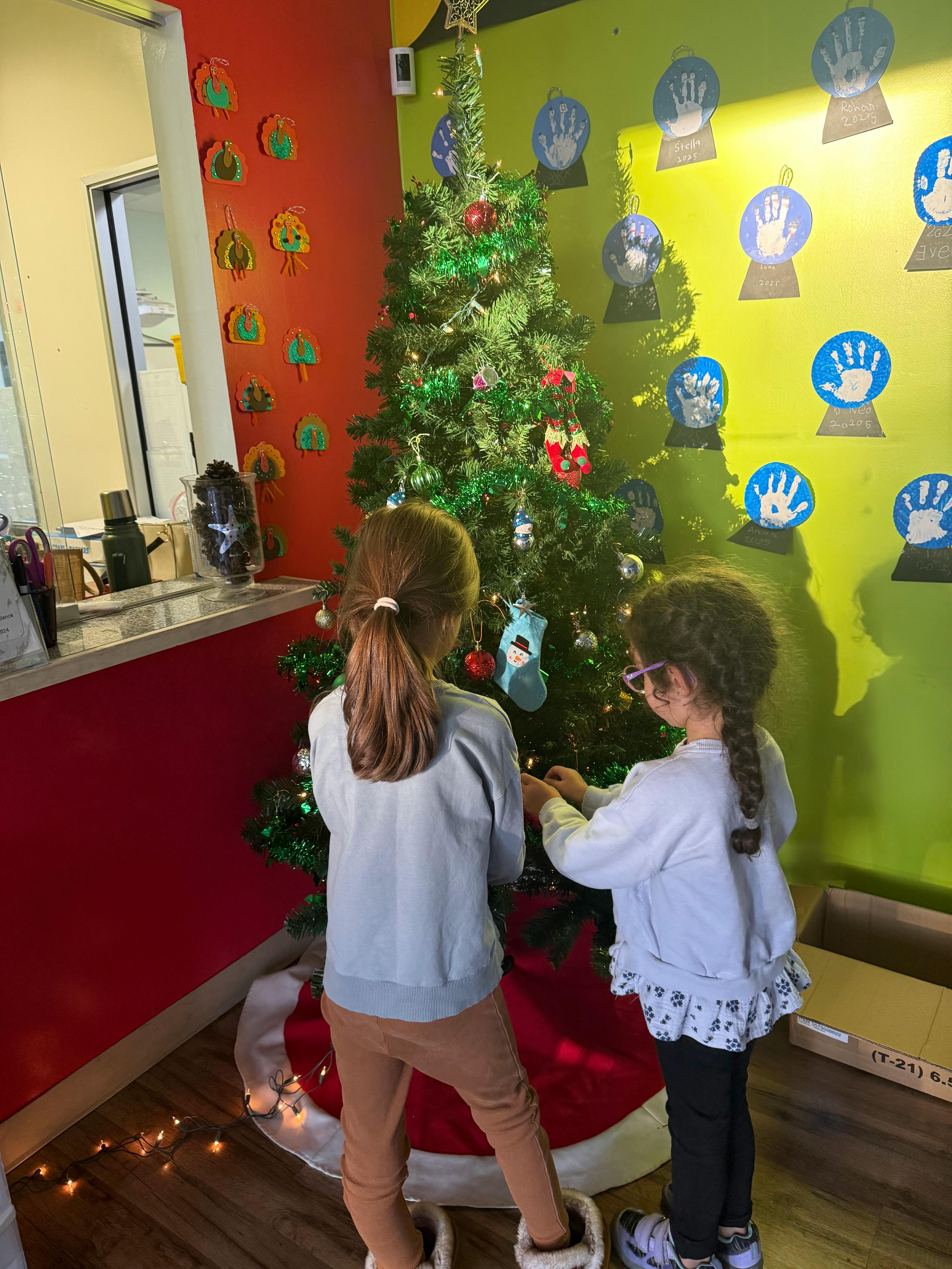 Two children decorating a Christmas tree with ornaments
