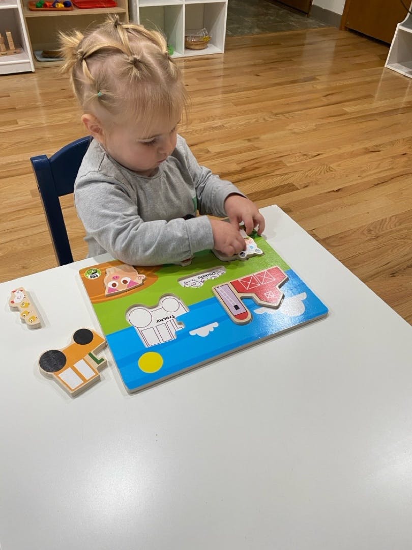 Child playing with a puzzle at a table